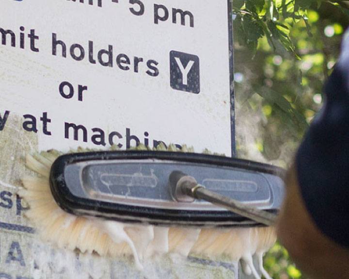 Road sign being cleaned